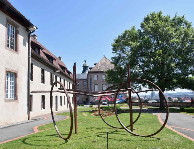 Moderne Skulptur auf der Wiese vor dem Eingang zum einstigen Schloss der Württemberger und heutigem Kunstmuseum Musée du Château des Ducs de Wurtemberg in Montbéliard (Mömpelgard).