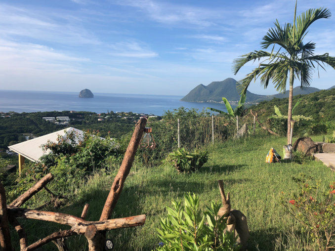 blick auf den felsen von le diamant aus einem garten von einem huegel martinique 